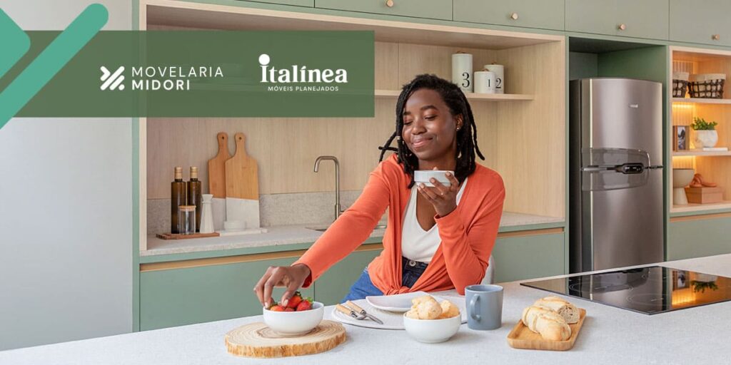 Mulher em frente a uma armário de cozinha completo verde Movelaria Midori Italínea Aclimação